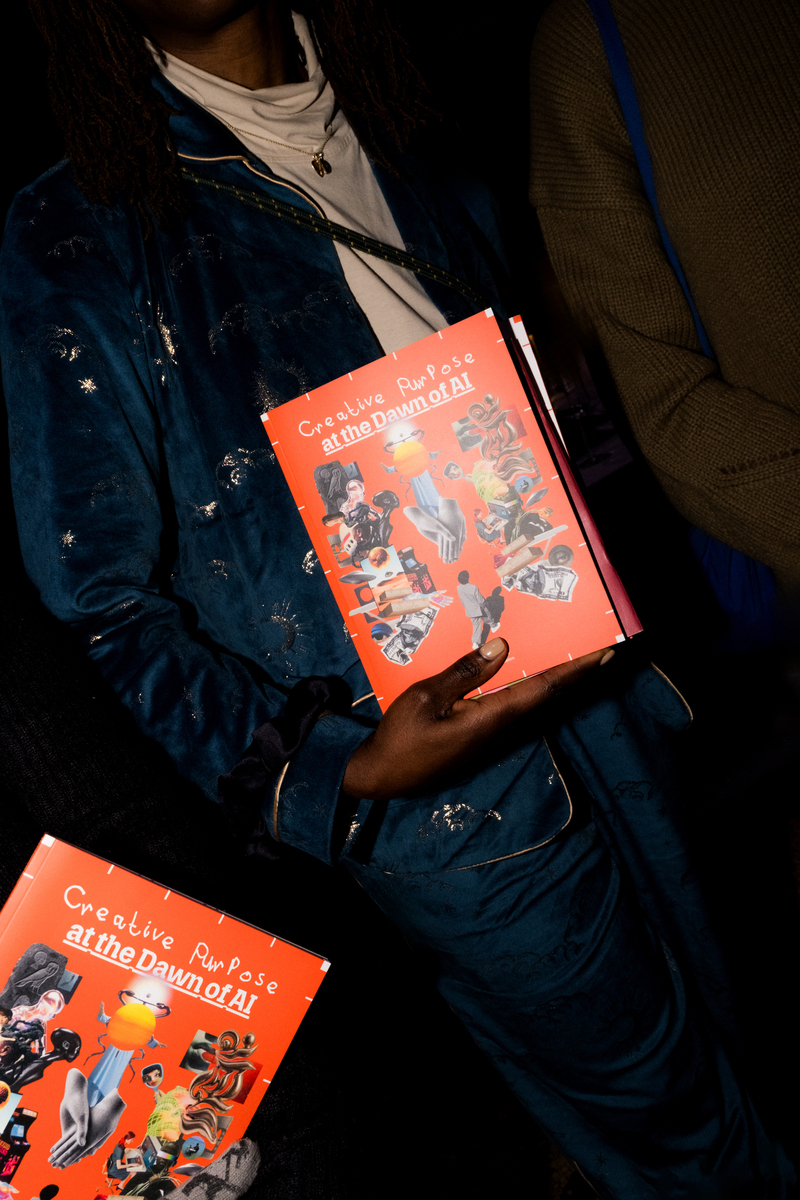 People holding the magazine Imagine Intel: Creative Purpose at the Dawn of AI at a dinner in Berlin